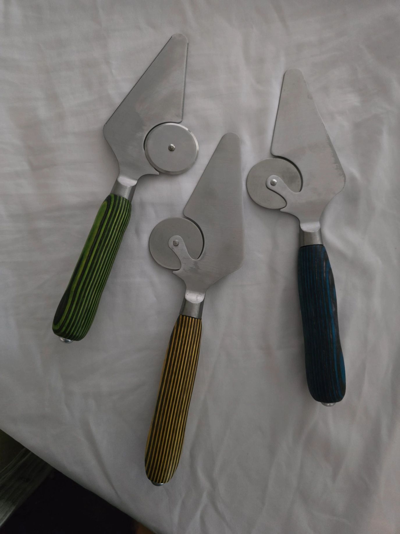 Paint rollers with textured handles in green, gold, and blue