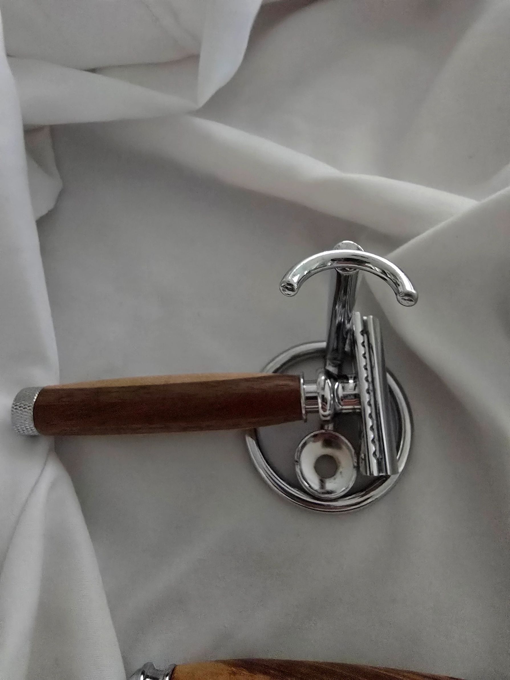 Classic safety razor with wooden handle on white fabric