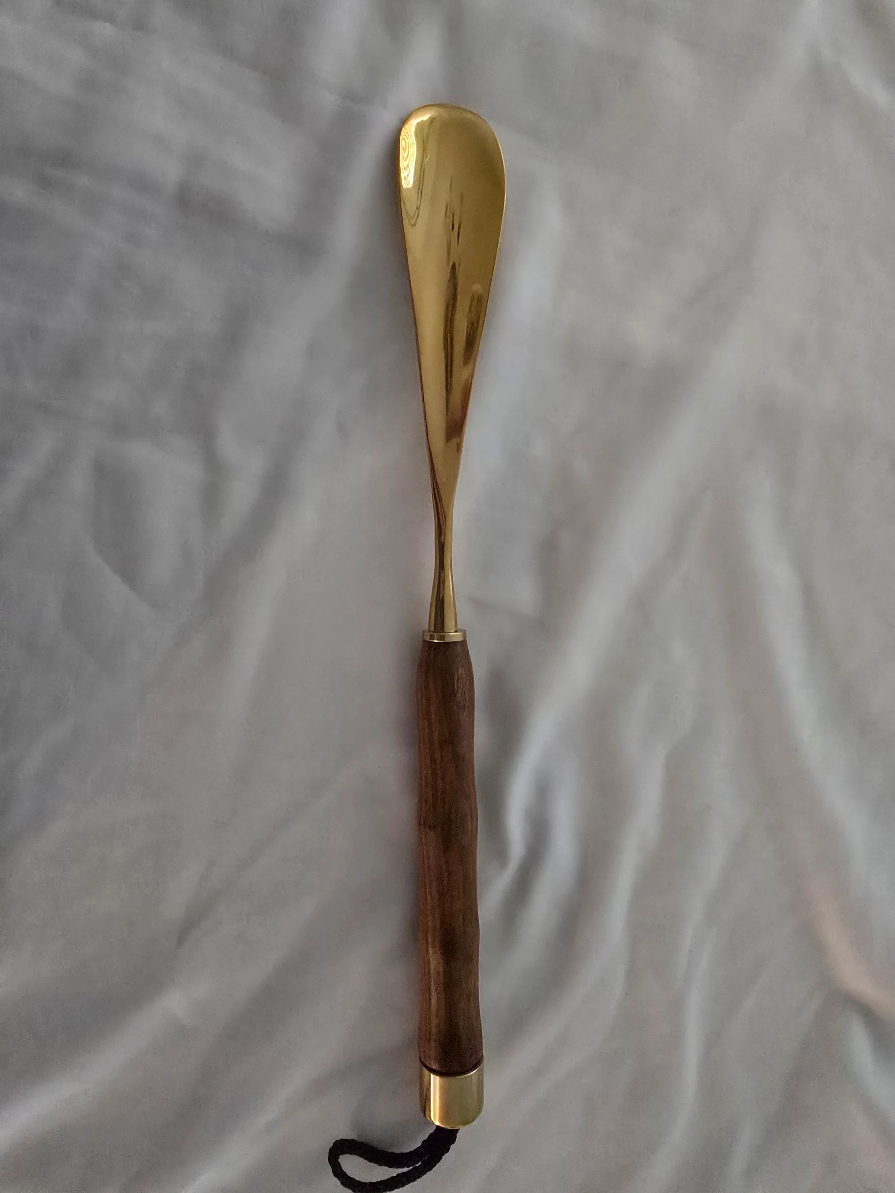 Vintage shoehorn with dark wood handle and brass head
